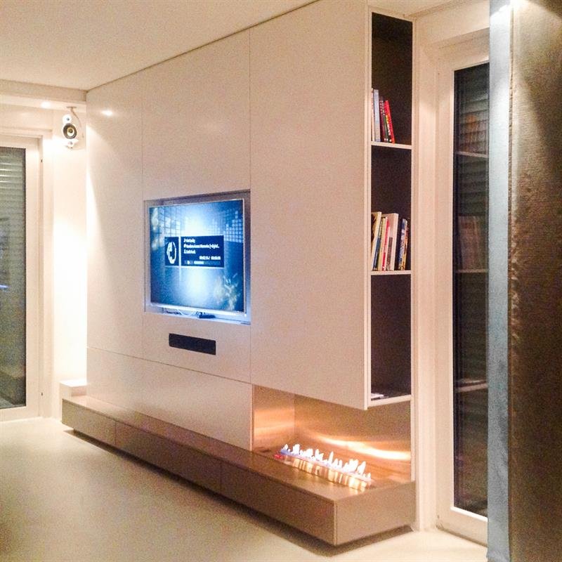 Weiße Wohnwand mit eingelassenem Fernseher, Kamin und offenem Regal